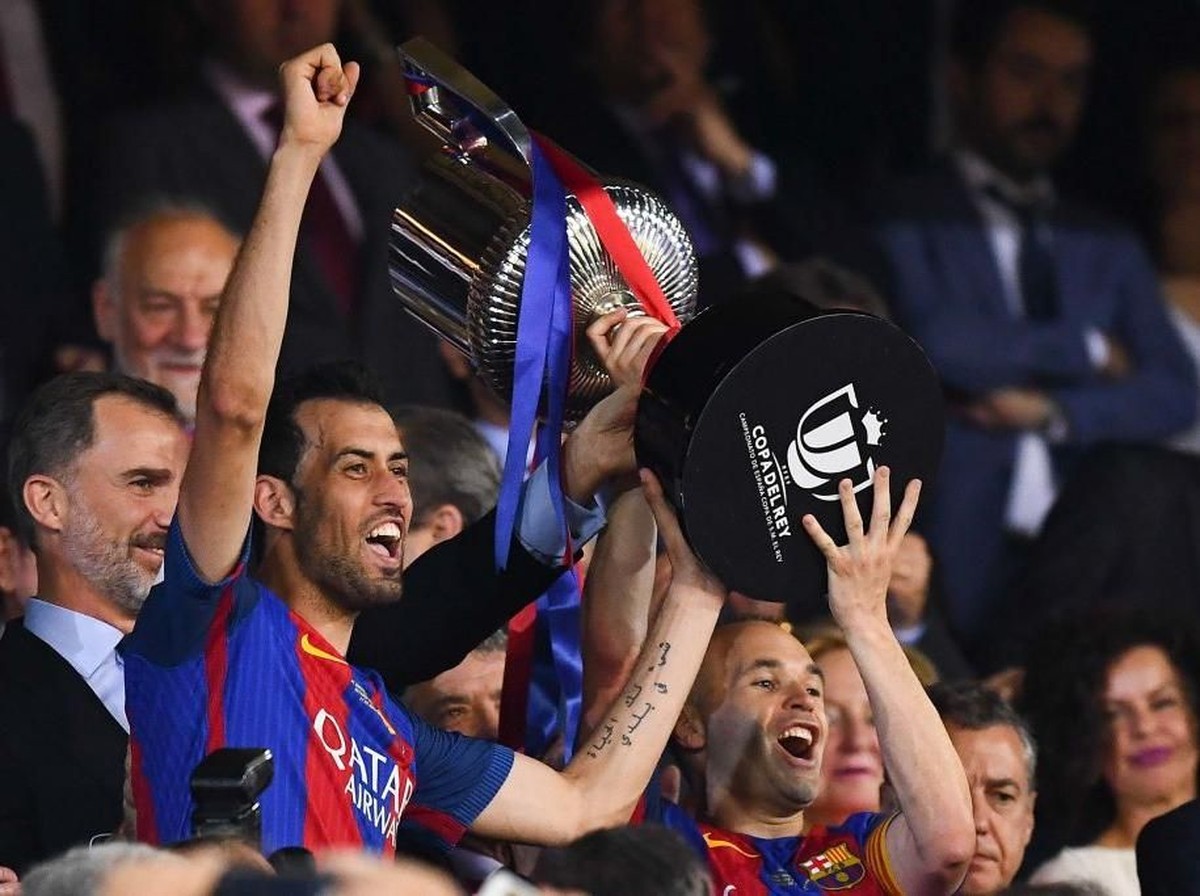 Sergio Busquets dan Andres Iniesta ketika mengangkat trofi Copa del Rey musim lalu (Foto: David Ramos/Getty Images)