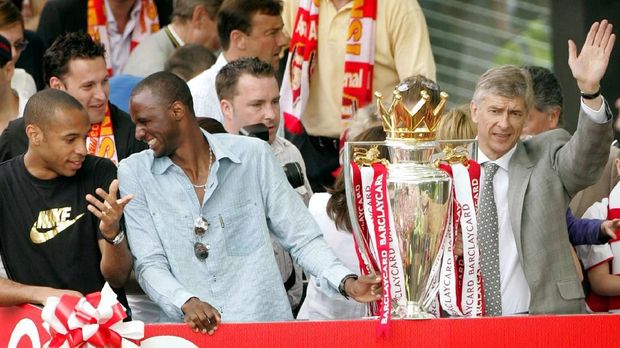 FILE PHOTO: Arsenal's Thierry Henry, Patrick Viera and manager Arsene Wenger celebrate during a victory parade in north London May 16, 2004. Arsenal are celebrating their victory in the English premier league. Arsenal became the first team since Preston North End's 