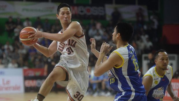 Pebasket Pelita Jaya Xaverius Prawiro (kiri) mencoba melewati hadangan pebasket Satria Muda Christian Sitepu (kanan)