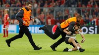 Lagi-lagi penyusup lapangan yang ini pun diringkus oleh steward pertandingan. (Foto: Kai Pfaffenbach/Reuters)