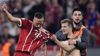 Saking ngototnya, penyusup lapangan ini masih berusaha menarik Ribery walaupun sudah berada dalam cengkeraman steward. (Foto: JAVIER SORIANO/AFP)