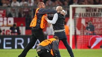 Sampai jatuh bangun, steward pertandingan langsung mengamankan penyusup lapangan yang memburu Kroos. (Foto: Michael Dalder/Reuters)