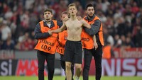 Beberapa steward ikut turun tangan dalam menggelandang si penyusup lapangan, yang sudah tanpa baju, meninggalkan lapangan. (Foto: Thorsten Wagner/Reuters)