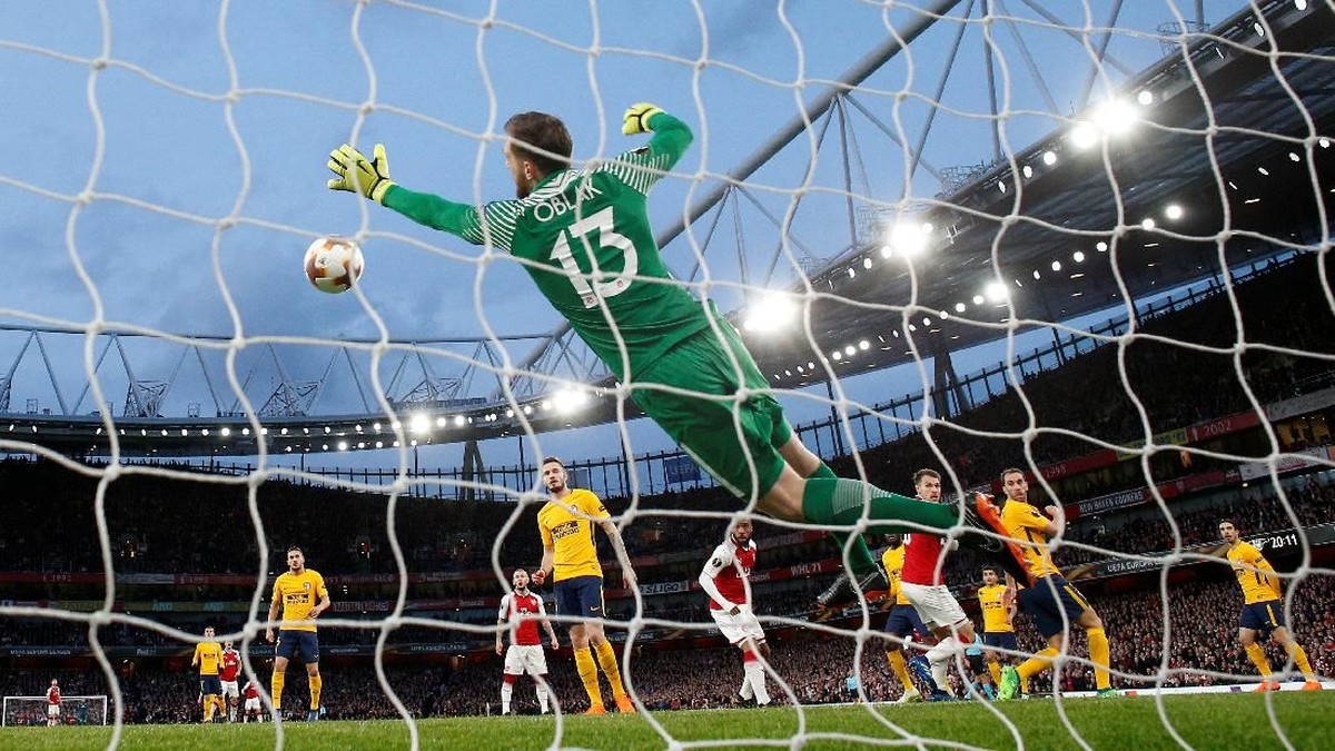 Aksi Jan Oblak ketika menggagalkan salah satu peluang Arsenal di leg pertama (Foto: Andrew Couldridge/Action Images via Reuters)
