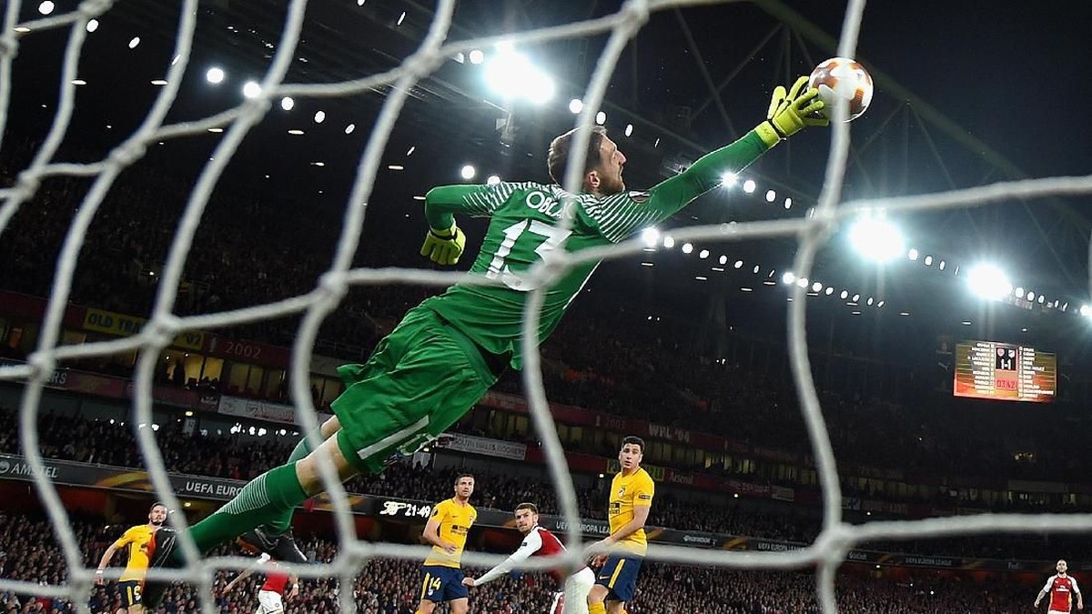Aksi Jan Oblak saat menggagalkan peluang Aaron Ramsey (Foto: Mike Hewitt/Getty Images)