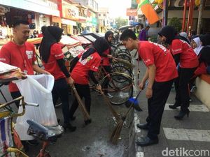 Peringati May Day, Karyawan Toserba dan Polwan Bersihkan Jalan