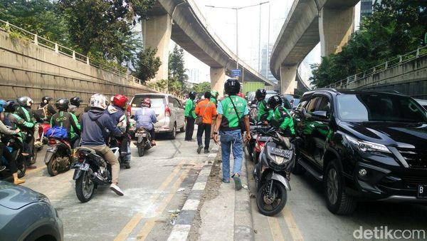 Foto: Aksi Ojol Bongkar Perbaikan Jalan Penyebab Macet di Casablanca