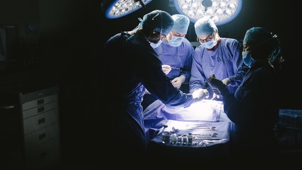 ilustrasi operasi ganti kelamin Doctors during surgery on patient in hospital. Surgeons team working at the hospital performing surgical procedure in operating theatre.