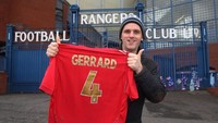 Kabar Gerrard bakal menjadi manajer Rangers sudah diketahui para fans. Derek Devin, fans Rangers, langsung berpose di depan Stadion Ibrox dengan membentangkan jersey merah Timnas Inggris bernomor 4 milik Gerrard. (Foto: Ian MacNicol/Getty Images)