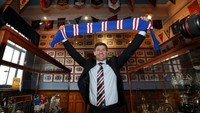 Tak pakai lama, Gerrard langsung berpose membentangkan syal khas Rangers berwarna biru merah. Ini menjadi petualangan pertamanya menjadi manajer utama sebuah klub profesional. (Foto: Scott Heppel/Reuters)