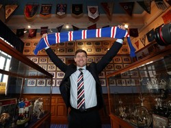 Tak pakai lama, Gerrard langsung berpose membentangkan syal khas Rangers berwarna biru merah. Ini menjadi petualangan pertamanya menjadi manajer utama sebuah klub profesional. (Foto: Scott Heppel/Reuters)