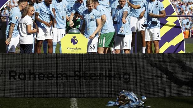 Beberapa pemain Manchester City menyadari trofi Liga Primer Inggris terjatuh.