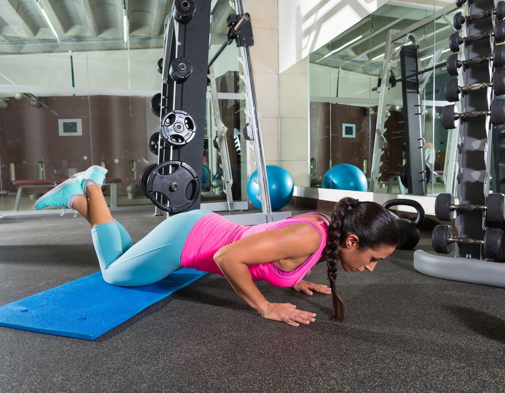 sport, fitness, bodybuilding, lifestyle and people concept - man and woman with dumbbells flexing muscles in gym