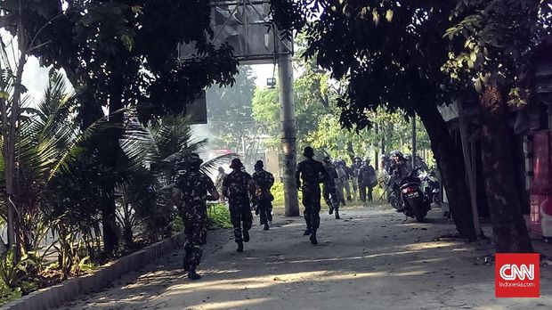 Petugas membubarkan warga yang membakar ban dan memblokade jalan saat aksi penolakan pengosongan rumah dinas TNI di Komplek Asrama Kodam, Kebayoran Lama, Jakarta, Rabu (9/5).