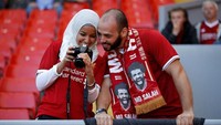 Melihat atribut yang dipakai kedua suporter Liverpool ini, sudah jelas mereka dari negara mana dan mendukung siapa dong? (Phil Noble/Reuters)