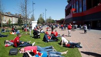 Para penonton bersantai menikmati matahari kota Liverpool sebelum pertandingan dimulai. Sinar matahari adalah barang langka di Inggris. (Carl Recine/Reuters)