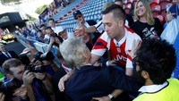 Fans Arsenal yang ini berusaha menggapai Wenger untuk merangkulnya. Wenger tampak tak keberatan. (Foto: Andrew Boyers/Action Images via Reuters)