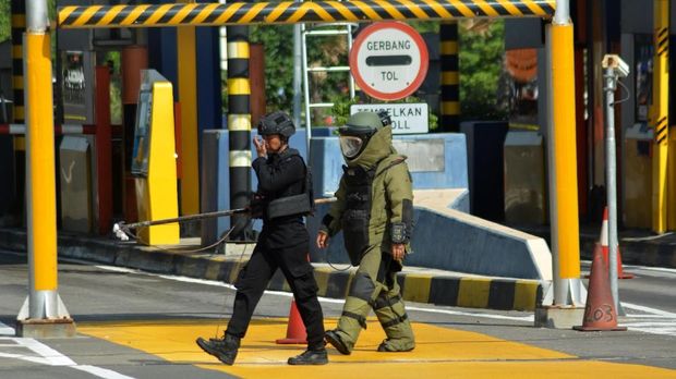 Tim Gegana Sat Brimob Polda Jawa Timur saat menjinakkan sebuah benda yang diduga bom di loket Pintu masuk Tol Sidoarjo, Jawa Timur, Jumat (18/5/2018)
