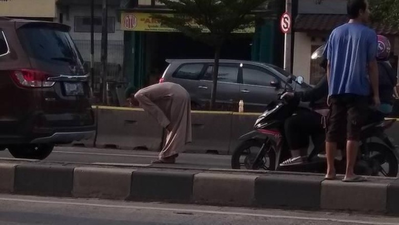 Diklakson Truk, Pria Bergamis yang Salat di Tengah Jalan Bergeming