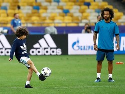 Setelah berlatih serius, para pemain Madrid latihan dengan santai sambil membawa anaknya masing-masing ke lapangan. Terlihat Marcelo sedang asyik menyaksikan anaknya, Enzo Vieira, bermain bola. (Foto: Kai Pfaffenbach/Reuters)