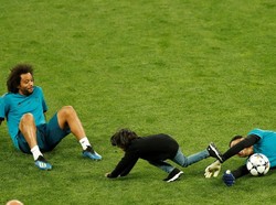 Kiper Keylor Navas, yang dituntut fokusnya di final nanti, juga asyik bermain-main dengan anaknya Meto Navas Salas di lapangan. Sementara Marcelo asyik menyaksikan rekannya itu bercanda. (Foto: Andrew Boyers/Reuters)