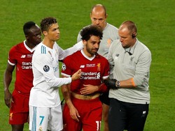 Cristiano Ronaldo mencoba menghibur Salah sebelum dia beranjak meninggalkan lapangan. (REUTERS/Phil Noble)