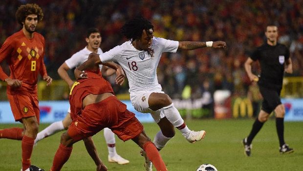 Gelson Martins berupaya melewati Vincent Kompany dalam laga persahabatan di Brussels.