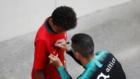 Meski sedang sibuk latihan, Ronaldo tak lupa meluangkan waktu menandatangani jersey Portugal yang dipakai seorang bocah. (Rafael Marchante/REUTERS)