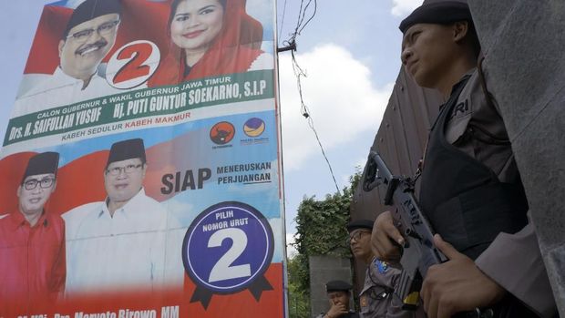 Aparat bersenjata berjaga saat KPK menggeledag rumah Syahri Mulyo, di Ngantru, Tulungagung, Jawa Timur, Sabtu (9/6).