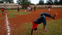 Unik, seorang bocah di Kenya melakukan atraksi dengan melompat sambil salo usai mencetak gol. REUTERS/Thomas Mukoya.
