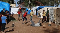 Kamp pengungsian Zaizon di Suriah tak membuat anak-anak berhenti bermain sepakbola. Mereka bermain dengan penuh semangat. REUTERS/Alaa al-Faqir.
