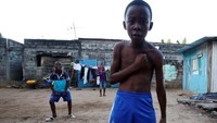 Seorang bocah 11 tahun bernama Jean-Christ asal Pantai Gading tengah berpose di depan kamera usai mencetak gol. REUTERS/Thierry Gouegnon.