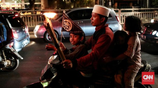 Masyarakat Ibu kota Jakarta warga merayakan malam takbiran dengan pawai obor keliling menyusuri jalan raya. Malam ini masyarakat akan merayakan takbiran untuk menyambut Hari Raya Idul Fitri 1439 Hijriah. Jakarta. Kamis,14 Juni 2018.CNN Indonesia/Andry Novelino