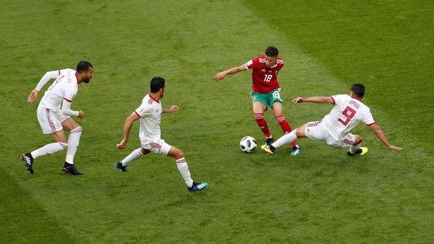 Amine Harit berupaya melewati tiga pemain Iran dalam laga Grup B Piala Dunia 2018.