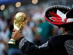 Dengan pede-nya pendukung Meksiko menentang replika tropy piala dunia. REUTERS/Carl Recine.