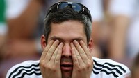Menutup mata karena malu sang juara bertahan kalah di laga perdana. REUTERS/Carl Recine.