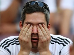 Menutup mata karena malu sang juara bertahan kalah di laga perdana. REUTERS/Carl Recine.