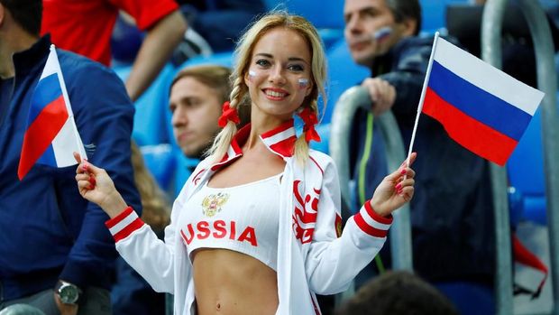 Salah seorang suporter wanita timnas Rusia memegang bendera jelang laga melawan Mesir.
