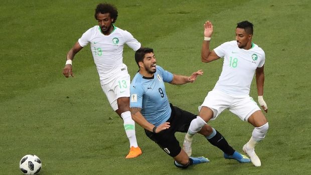 Pemain timnas Uruguay Luis Suarez dihadang oleh pemain timnas Arab Saudi Yasser Al-Shahrani dan Salem Al-Dawsari, dalam pertandingan di Rostov Arena, Rostov-on-Don, Rusia, 20 Juni.