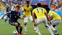 Genki Haraguchi berusaha melawati kepungan pemain Kolombia. Reuters/Damir Sagolj.