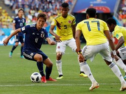 Genki Haraguchi berusaha melawati kepungan pemain Kolombia. Reuters/Damir Sagolj.
