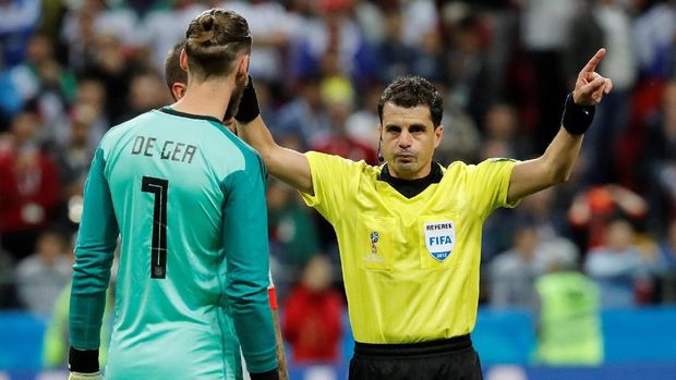 Wasit Andres Cunha memberikan gestur menjadikan VAR sebagai pertimbangan sebelum membuat keputusan.