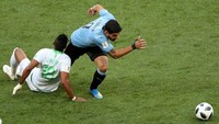 Luis Suarez berusaha melewati Salem Al-Dawsari dalam pertandingan yang dihelat di Rostov Arena, Rabu (20/6/2018) malam. Reuters/Marcos Brindicci.