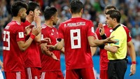 Tapi wasit Andres Cunha meminta gol itu ditinjau VAR karena hakim garis mengangkat bendera offside. Pemain Iran pun langsung mengerubungi wasit melakukan protes. (Foto: Reuters)