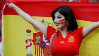 Pendukung Spanyol membentangkan bendera sambil tersenyum saat menyaksikan laga melawan Iran yang berakhir dengan skor 1-0. Reuters/Jorge Silva.