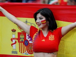 Pendukung Spanyol membentangkan bendera sambil tersenyum saat menyaksikan laga melawan Iran yang berakhir dengan skor 1-0. Reuters/Jorge Silva.