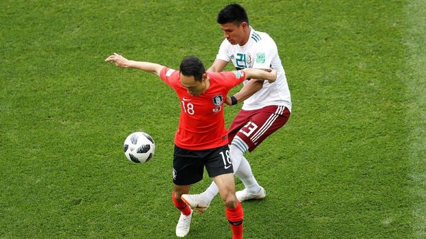 Gelandang Korea Selatan Moon Seon-min berduel dengan bek Meksiko Jesus Gallardo.