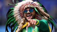 Menggunakan hiasan kepala ala Suku Amazon, suporter ini terlihat asyik merayakan kemenangan Selecao yang berhasil tundukkan Los Ticos dengan hasil akhir 2-0. Istimewa/Chris Brunskill/Fantasista/Getty Images.