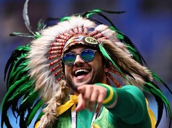 Menggunakan hiasan kepala ala Suku Amazon, suporter ini terlihat asyik merayakan kemenangan Selecao yang berhasil tundukkan Los Ticos dengan hasil akhir 2-0. Istimewa/Chris Brunskill/Fantasista/Getty Images.