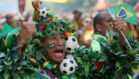 Suporter Brasil ini mengunakan kostum dari daun dengan berbagai hiasan bola dan bendera Brasil saat menonton pertandingan Brasil melawan Kosta Rika. Istimewa/Sergio Moraes/Reuters.